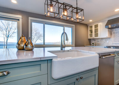 Beautiful kitchen room with green island and farm sink.